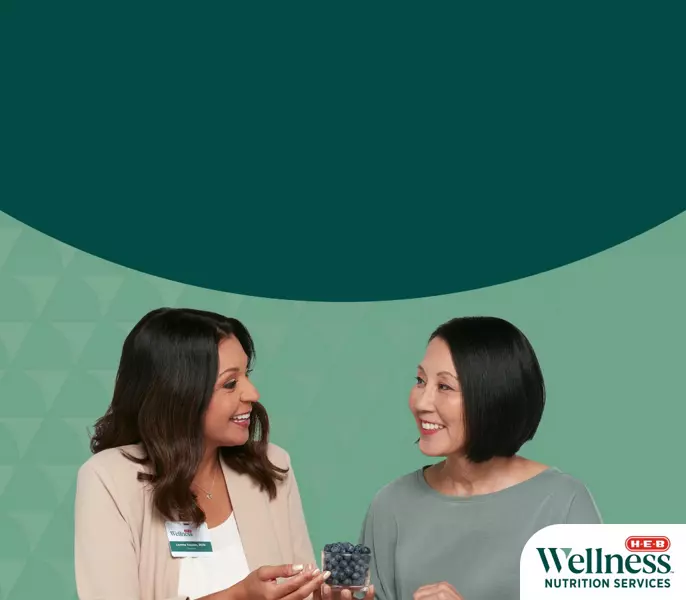 An H‑E‑B Dietitian having a consultation while holding a cup of blueberries