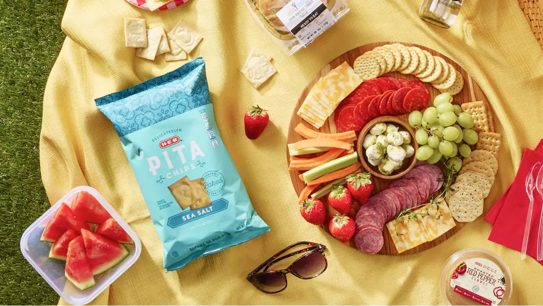 Picnic essentials, pita chips, watermelon, cheeseboard, hummus