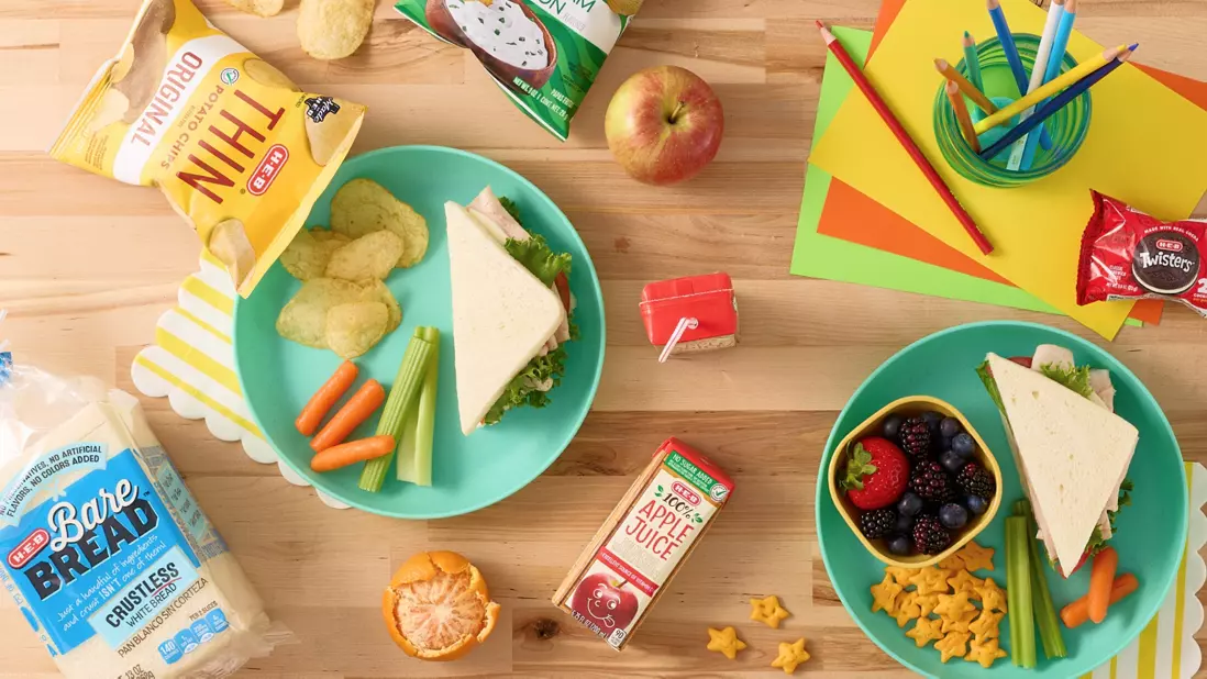 Bread, thin lays, carrots, apple juice, fruit in a cup, colored pencils in a jar