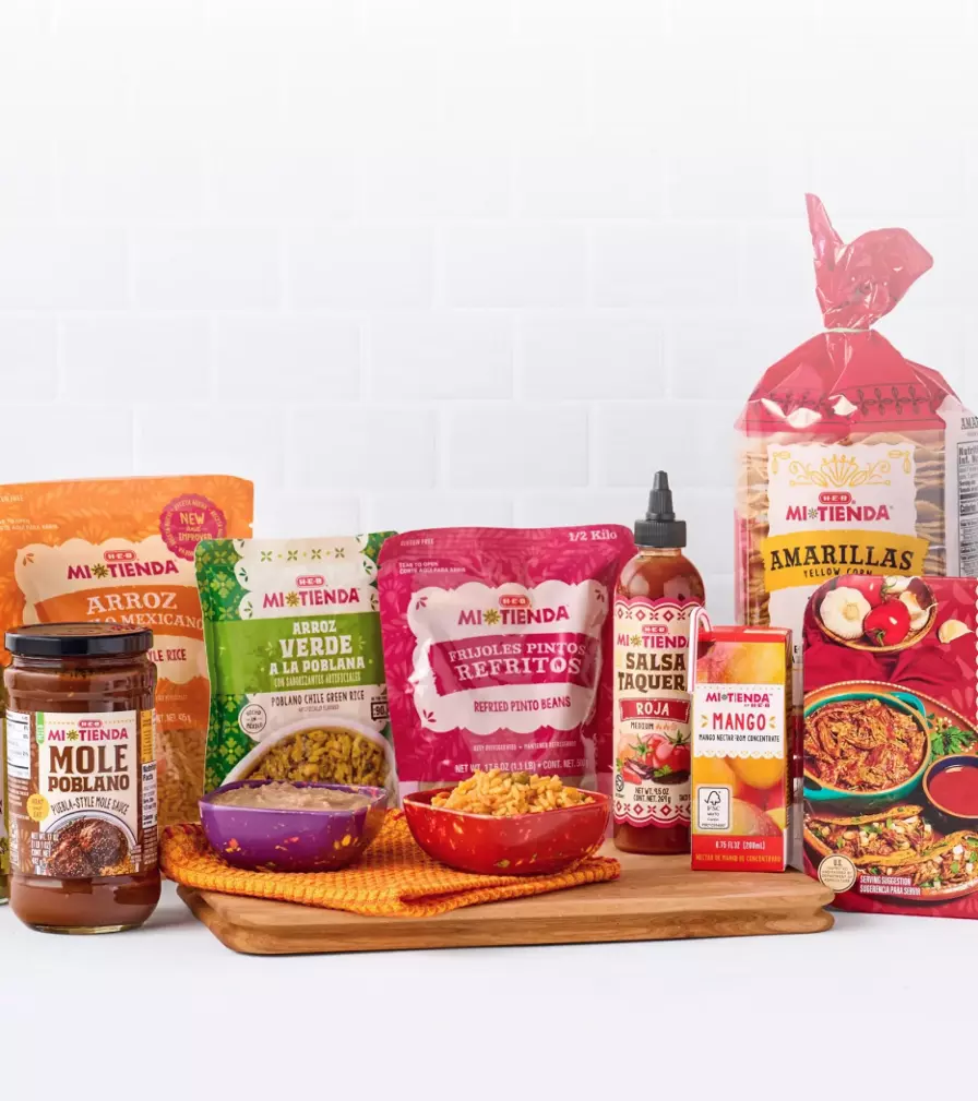 Promotional banner for Mi Tienda products featuring arroz, salsa verde, mole poblano sauce, tortillas, birria de res, hot sauce, and seasonings. Text reads: “Get $4 off $20 selected H‑E‑B Mi Tienda products.”