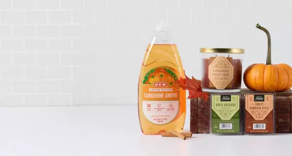 Fall home décor promotional banner featuring the headline “Welcome fall with a home refresh” on a light gray background. Seasonal home fragrance and décor products are displayed on the right, including scented candles, wax melts, potpourri, a bag of tangerine grapefruit-scented product, decorative leaves, and a small orange pumpkin. The warm autumn colors and seasonal accents highlight fall-inspired home refresh essentials.
