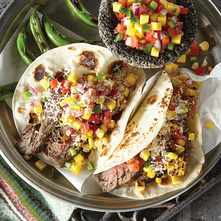 Grilled steak fajitas topped with corn salsa and served on a flour tortilla